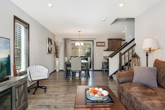 living room featuring a chandelier, stairway, wood finished floors, and recessed lighting