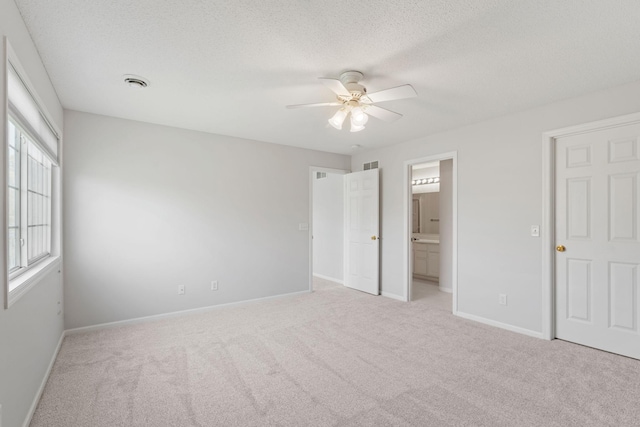 15721 France Way Unit 1312, Apple Valley, MN 55124 - unfurnished bedroom featuring a textured ceiling, baseboards, ensuite bath, and light colored carpet