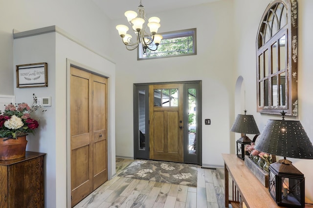 11259 71st Ave N, Maple Grove, MN 55369 - foyer entrance featuring a chandelier, a towering ceiling, light wood-style flooring, and arched walkways