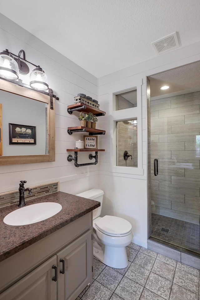 11259 71st Ave N, Maple Grove, MN 55369 - bathroom featuring a stall shower, vanity, toilet, tile patterned floors, and a textured ceiling