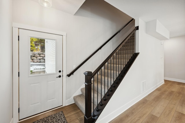 entrance foyer featuring visible vents, stairway, hardwood / wood-style flooring, and baseboards