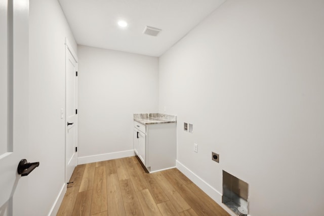 washroom with cabinet space, visible vents, baseboards, light wood-style flooring, and hookup for an electric dryer