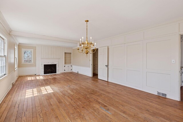 2148 Delaware Ave, Sunfish Lake, MN 55118 - unfurnished living room with a chandelier, light wood-style flooring, ornamental molding, a fireplace with flush hearth, and built in shelves