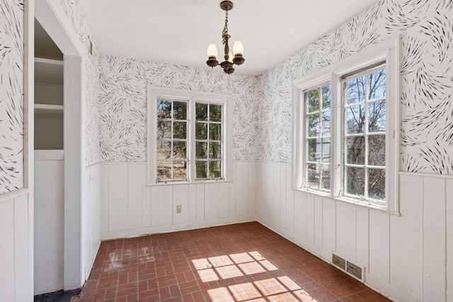 2148 Delaware Ave, Sunfish Lake, MN 55118 - unfurnished dining area featuring wallpapered walls, a wainscoted wall, brick patterned floors, and a chandelier
