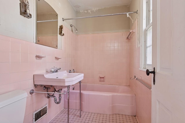 2148 Delaware Ave, Sunfish Lake, MN 55118 - bathroom featuring tile walls, toilet, bathtub / shower combination, and tile patterned flooring