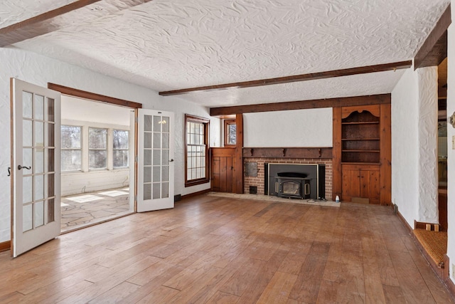 2148 Delaware Ave, Sunfish Lake, MN 55118 - unfurnished living room with wood-type flooring, a textured ceiling, beam ceiling, a wood stove, and built in features