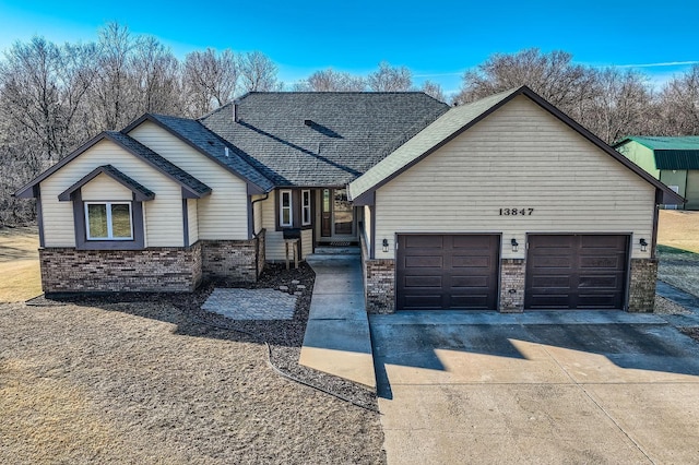 13847 Taconite St NE, Ham Lake, MN 55304 - view of front facade featuring brick siding, concrete driveway, a garage, and roof with shingles