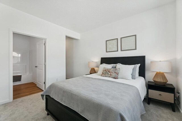 bedroom featuring visible vents, ensuite bathroom, and carpet floors