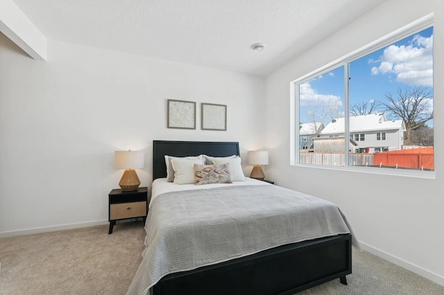 bedroom with a textured ceiling, baseboards, and carpet floors