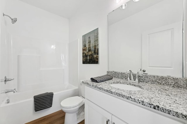 bathroom with vanity, wood finished floors, toilet, and tub / shower combination