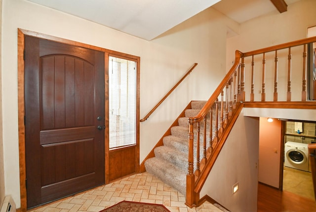 entryway featuring baseboard heating, stairway, washer / clothes dryer, and brick floor