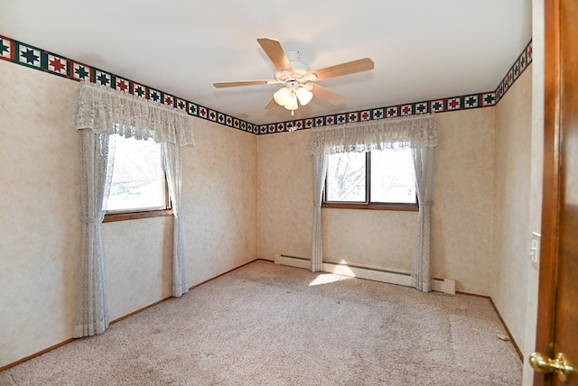 carpeted empty room featuring a baseboard heating unit and a ceiling fan