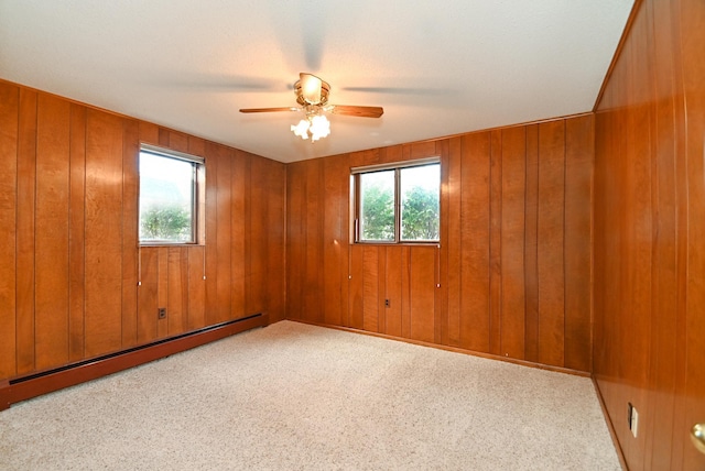 spare room with baseboard heating, carpet flooring, plenty of natural light, and ceiling fan