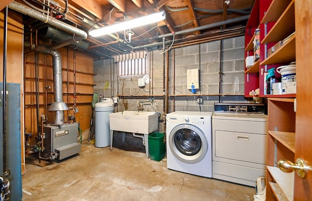 clothes washing area featuring washing machine and clothes dryer, laundry area, a heating unit, and a sink