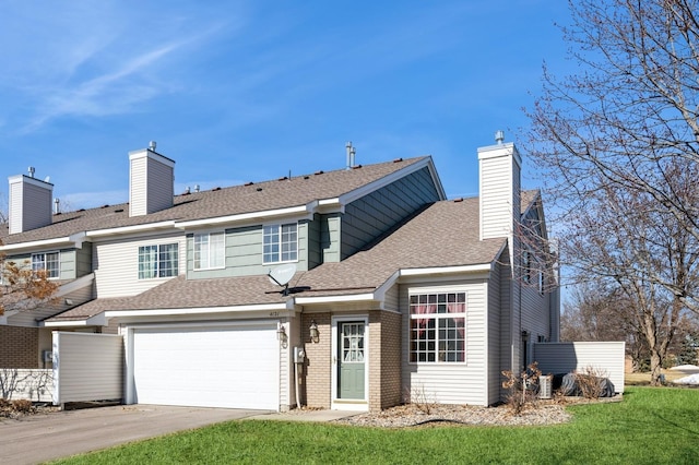 view of front of house with driveway, a front lawn, roof with shingles, brick siding, and a chimney