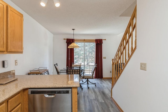 kitchen featuring a peninsula, baseboards, dishwasher, dark wood-style flooring, and hanging light fixtures