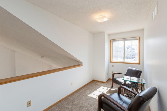 sitting room with carpet flooring, visible vents, a textured ceiling, and baseboards