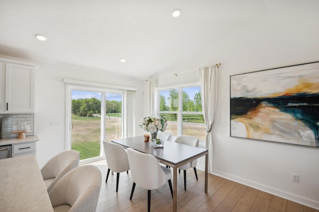 dining area featuring recessed lighting, vaulted ceiling, light wood-style flooring, and baseboards