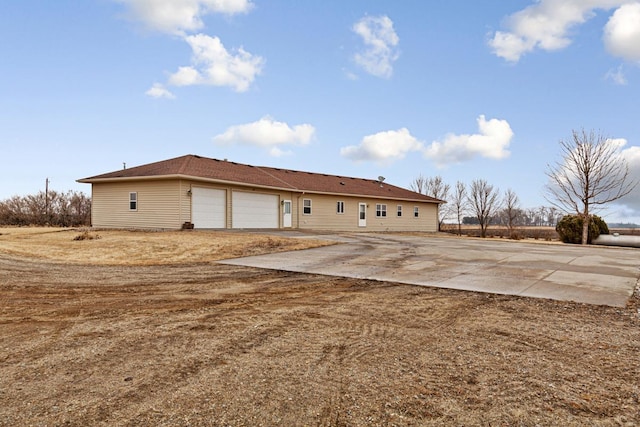 rear view of property with driveway and an attached garage