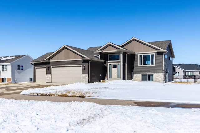 view of front of home with an attached garage, stone siding, and roof with shingles