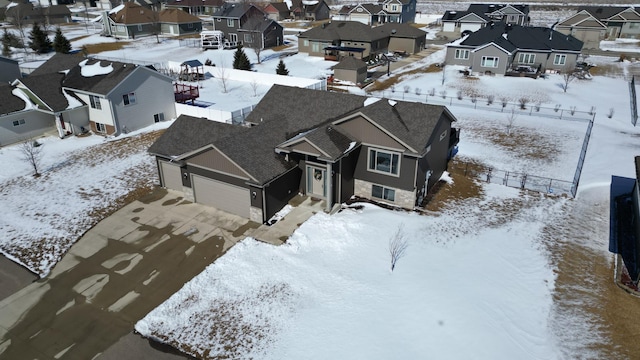 snowy aerial view with a residential view