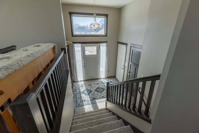 foyer entrance with a towering ceiling, stairs, and wood finished floors