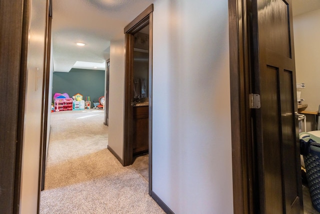 hallway with light carpet and baseboards