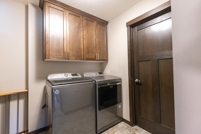 laundry room featuring light tile patterned floors, cabinet space, baseboards, and separate washer and dryer