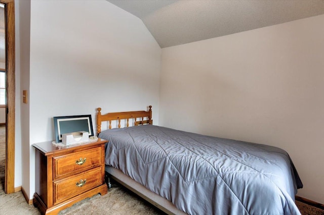 bedroom featuring light carpet, vaulted ceiling, and baseboards