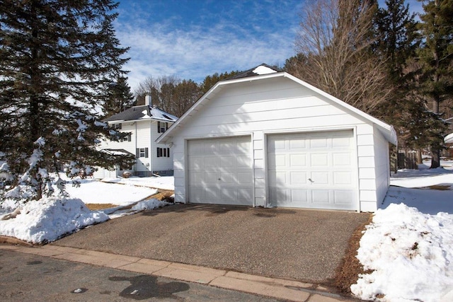 snow covered garage with a garage