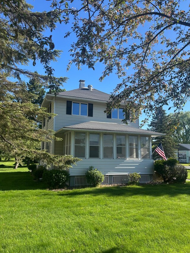 307 Oak St, Glenwood City, WI 54013 - view of front of house featuring a front yard, a chimney, and a shingled roof