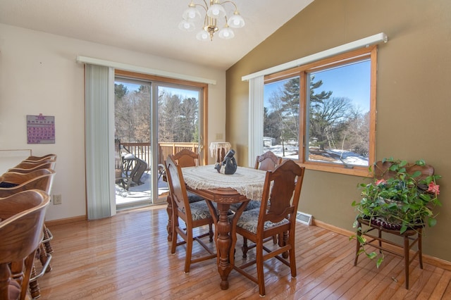 dining space with vaulted ceiling, light wood-style flooring, and a healthy amount of sunlight