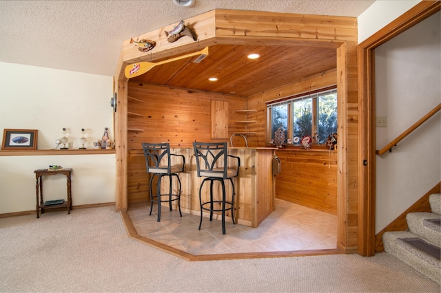 bar with carpet flooring, a textured ceiling, and stairs