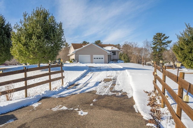 view of front of house with a garage, driveway, and fence