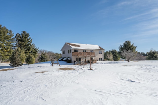 snow covered property featuring a deck and a garage