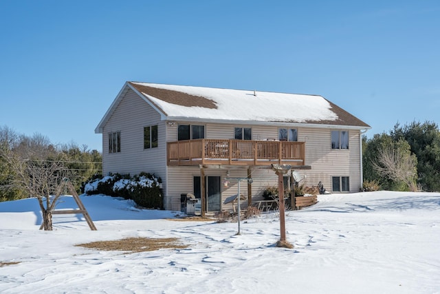 snow covered house with a wooden deck