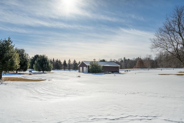 yard covered in snow with a garage and an outbuilding