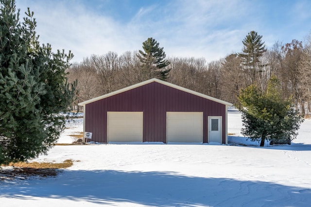 snow covered garage with a garage