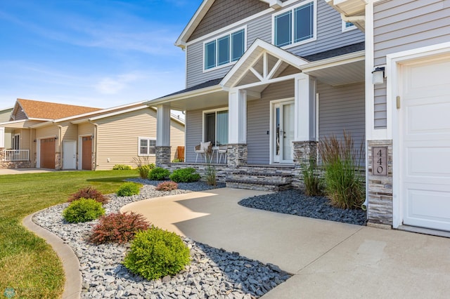 view of exterior entry with stone siding, covered porch, and an attached garage