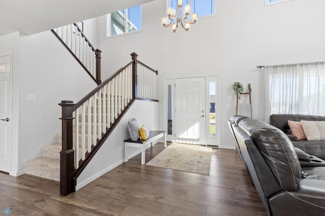 entryway with baseboards, stairway, a chandelier, and wood finished floors