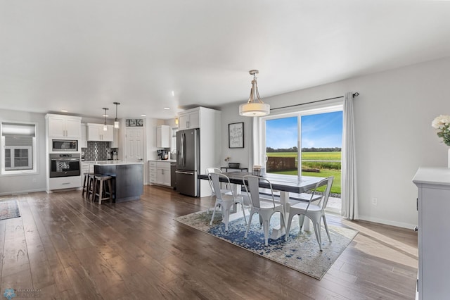 dining room with baseboards, dark wood finished floors, and recessed lighting