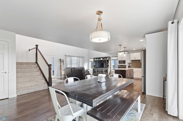 dining room with stairway, wood finished floors, and recessed lighting