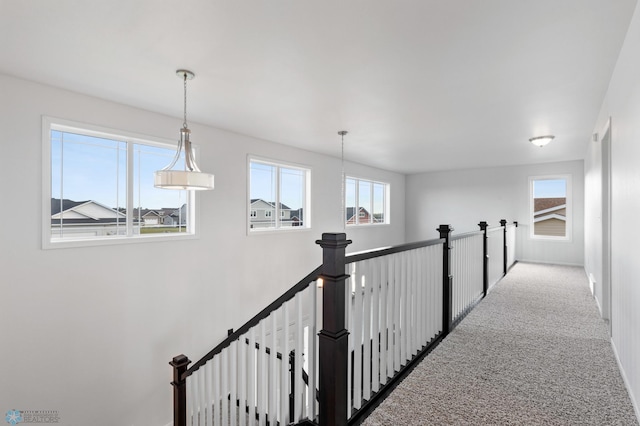 corridor with carpet flooring and an upstairs landing