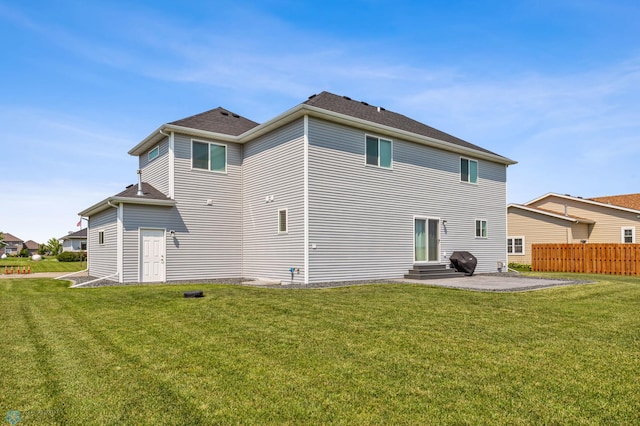 back of property featuring entry steps, a patio area, a yard, and fence