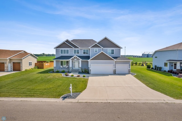 craftsman inspired home with a garage, a front yard, concrete driveway, and fence