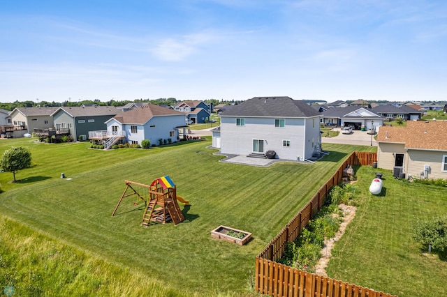 view of yard featuring a playground, fence, and a residential view