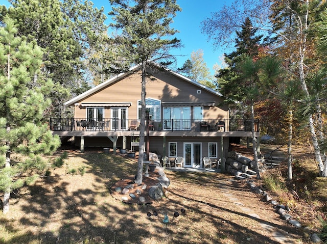 rear view of property featuring french doors and a wooden deck