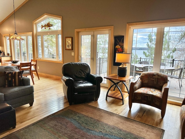 living room with lofted ceiling, light wood finished floors, and baseboards