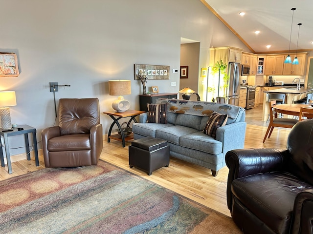 living area featuring baseboards, high vaulted ceiling, light wood finished floors, and recessed lighting