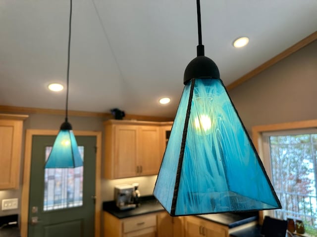 room details featuring hanging light fixtures, dark countertops, crown molding, and recessed lighting